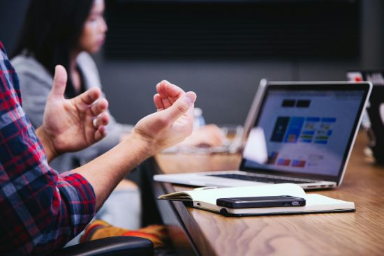 Réunion de travail en équipe avec ordinateur portable et échanges autour de la formation